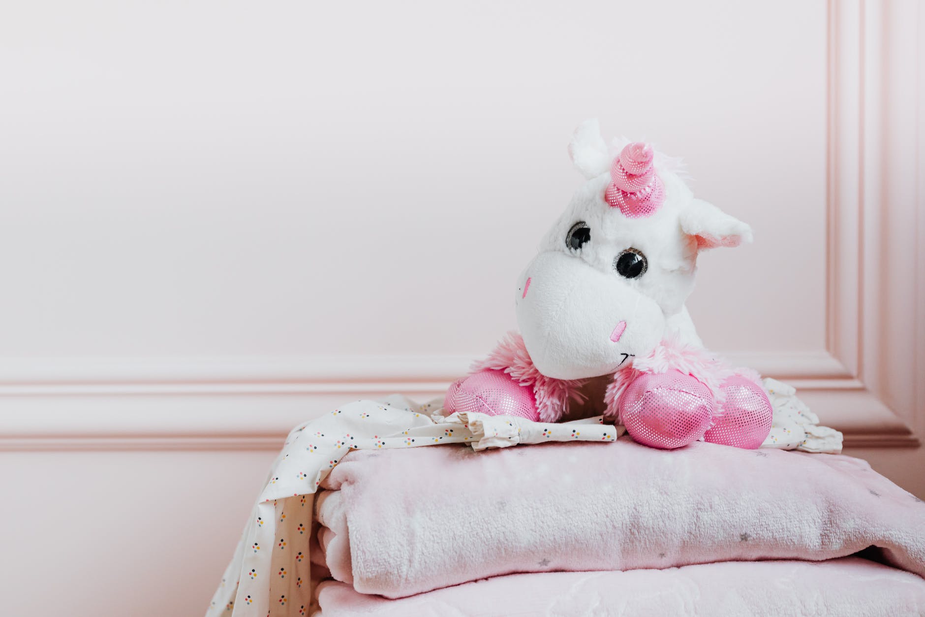 a unicorn stuffed toy on a blanket